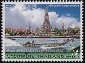 Wat Arun at the Chao Phraya River and a longtail boat speeding by